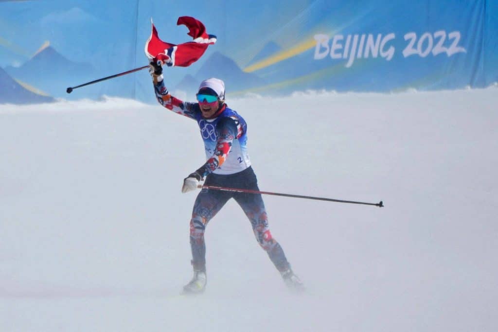 Johaug feirer OL-gull på tremila med det norske flagget.
